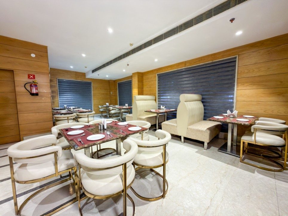 Brass-framed tub chairs and marble-top tables at Sakun, Hotel Sawera Grand