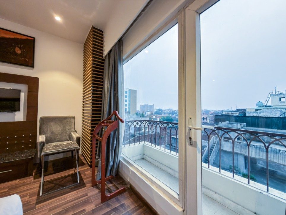 Floor-to-ceiling glass opening onto the balcony of a Business Room, Hotel Sawera Grand