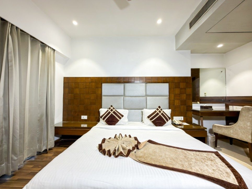 Padded headboard and bedside detail in a Business Room with Balcony, Hotel Sawera Grand
