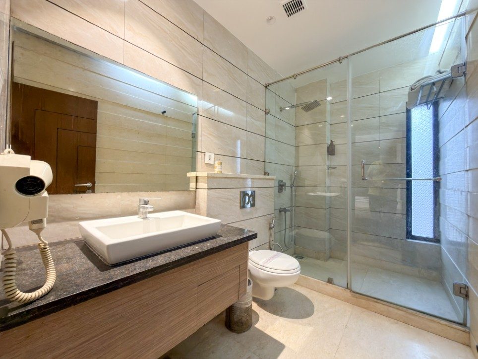 Marble bathroom with glass walk-in shower in the Executive Triple Room, Hotel Sawera Grand