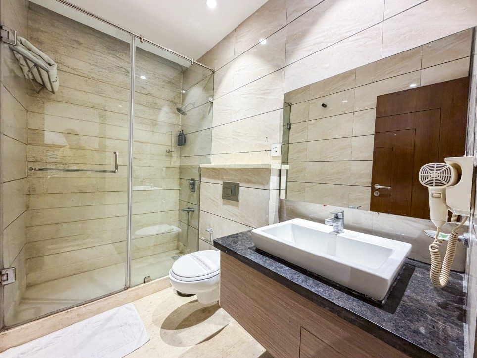Marble bathroom with glass walk-in shower in the Executive Twin Room, Hotel Sawera Grand